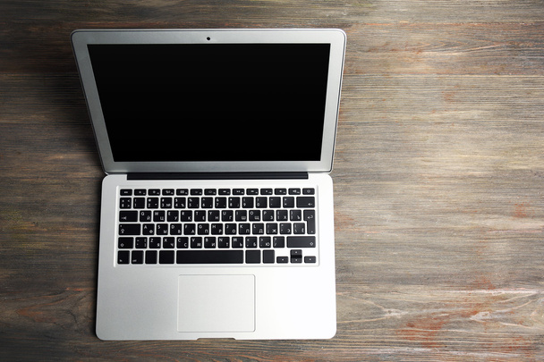 An open silver laptop on the wooden background - Фото, зображення