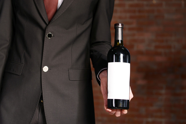Man holding bottle of red wine - Foto, Bild