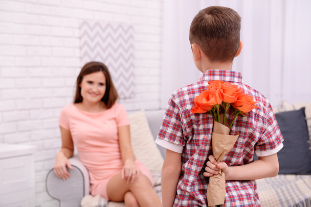 Son hiding roses for mother - Foto, afbeelding