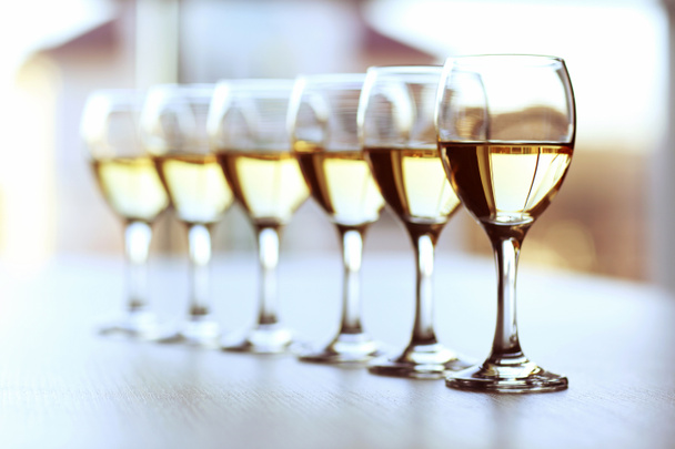 Row of wineglasses on light blurred background - 写真・画像