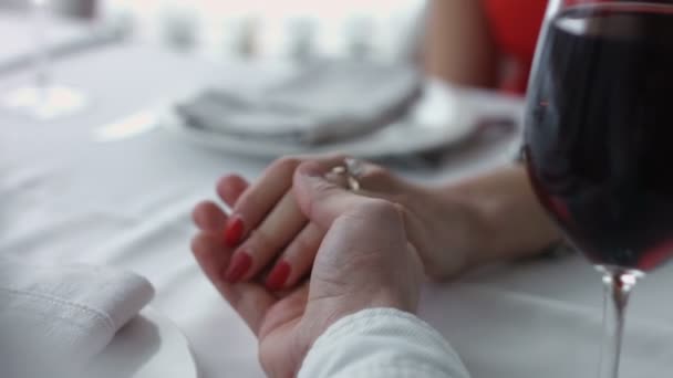Young couple holding each other hands at the restaurant. - Imágenes, Vídeo