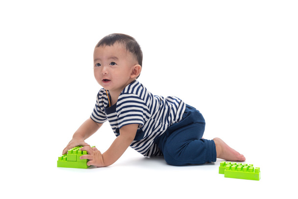 Asian baby is playing with plastic construction toys over white  - Fotografie, Obrázek
