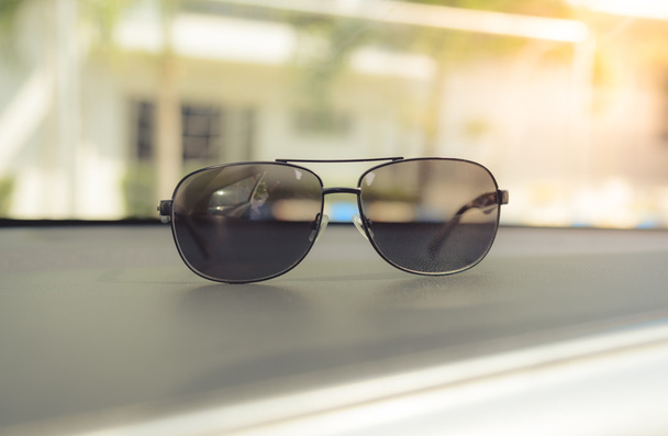 Concetto vintage di occhiali da sole sulla console auto. Focus selettivo
. - Foto, immagini