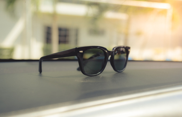 Concept vintage of sunglasses on the console car. Selective focus. - Photo, Image
