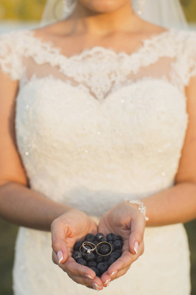 berries in the hands of the bride, on which lay a ring - Fotografie, Obrázek