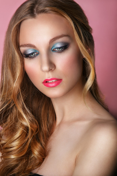 Beauty Model Mujer Cara sobre fondo rosa brillante. Piel perfecta. Maquillaje profesional.Ojos azules y labios rosados
. - Foto, imagen