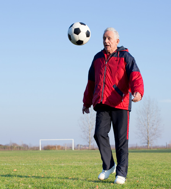 Old man playing football - Foto, afbeelding