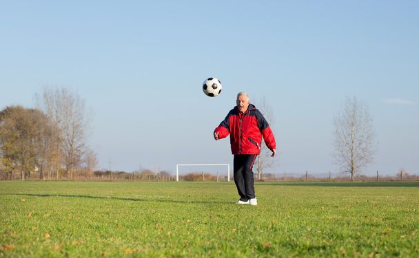 Vieil homme jouant au football
 - Photo, image