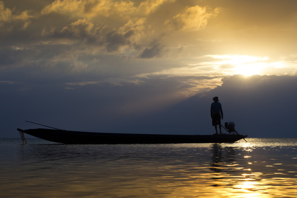 タイ、夕日と湖で漁師のシルエット. - 写真・画像