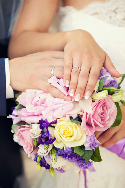 hands of groom and bride on a wedding bouquet - Valokuva, kuva