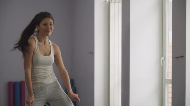 Szczęśliwa młoda kobieta tańczy w siłowni - Materiał filmowy, wideo