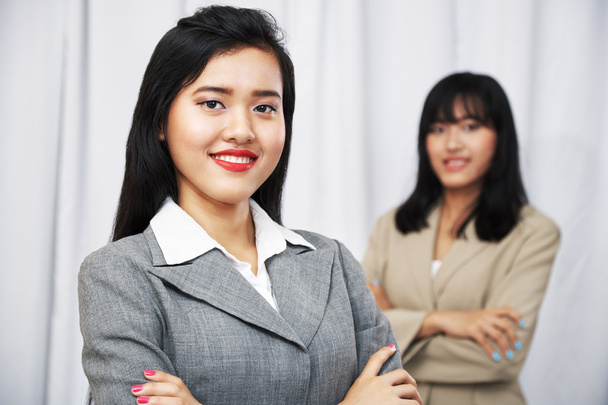 Businesswomen wearing suits standing and folding arms - Photo, Image