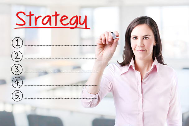 Business woman writing blank Strategy list. Office background. - Photo, Image