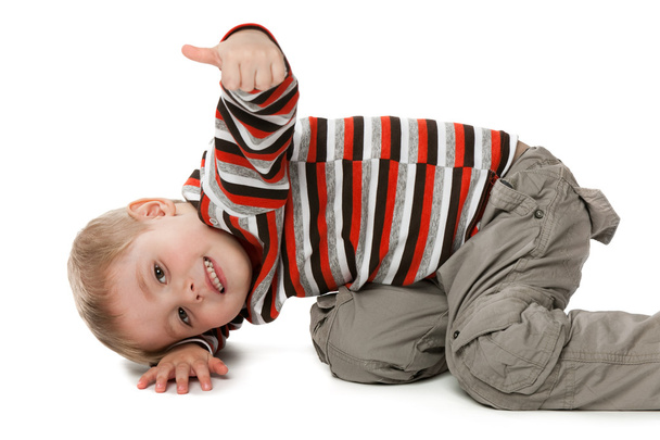A mischievous boy shows his thumb up isolated on the white background - Фото, зображення