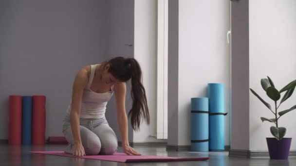 mujer sentada en la alfombra y haciendo ejercicios relajantes
 - Metraje, vídeo