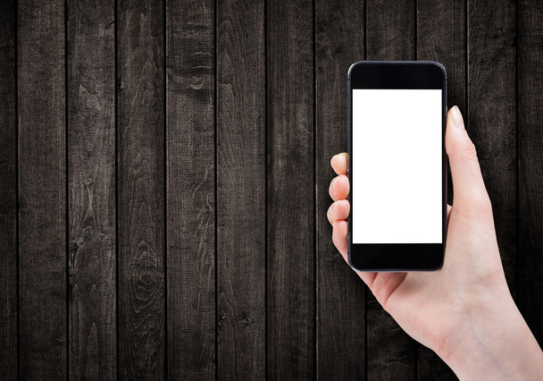 Female hand holding smart phone on wooden background  - Φωτογραφία, εικόνα