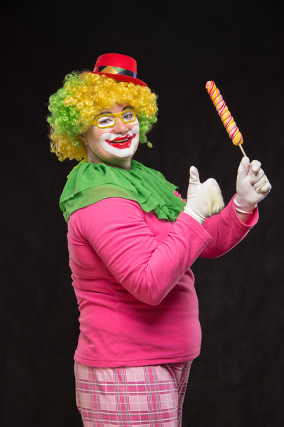 Веселий смішний клоун у капелюсі з великою цукеркою
 - Фото, зображення