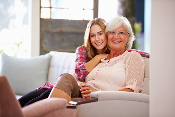 Grandmother With Granddaughter Relaxing On Sofa - Foto, Bild