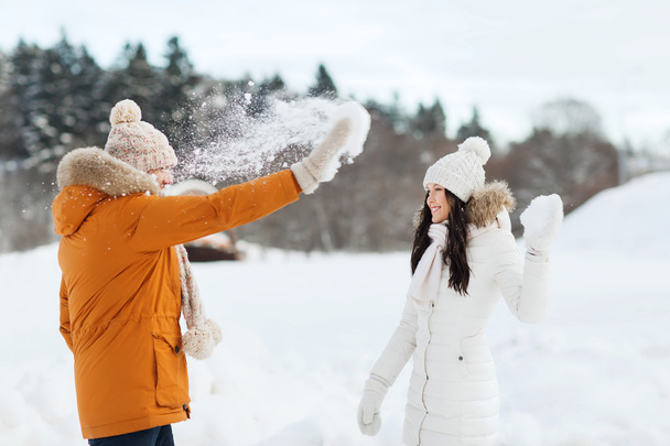 happy couple playing with snow in winter - Фото, изображение