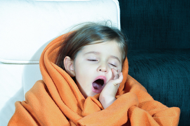 Hulladék lány ásítás. Beteg kislány takaró és csésze. Beteg gyermek cserepes ajkak. Hulladék lány influenza gyógyszert neki inni. - Fotó, kép