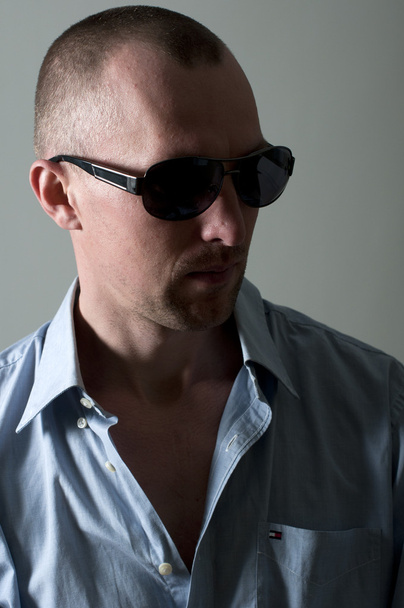 Serious young man in sunglasses in the studio - 写真・画像