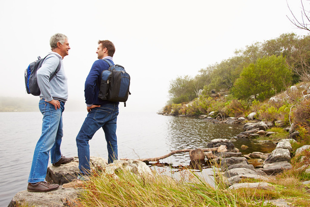 Father and adult son standing by a lake - Photo, image