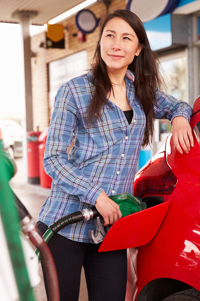 Woman refueling a car at a petrol station - Foto, immagini