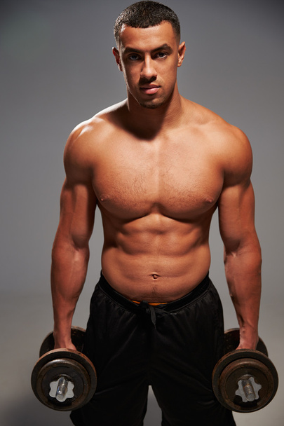 Male bodybuilder holding dumbbells - 写真・画像