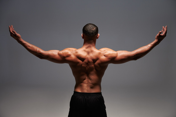 Male bodybuilder raising his arms - Fotó, kép