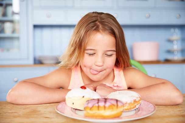 Girl Looking At Plate Of Sugary Cakes - Фото, изображение
