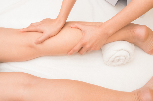 Therapist doing  massage on woman leg  in day spa - Foto, imagen