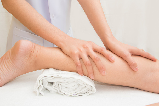 Terapista facendo massaggio sulla gamba della donna nella spa diurna
 - Foto, immagini