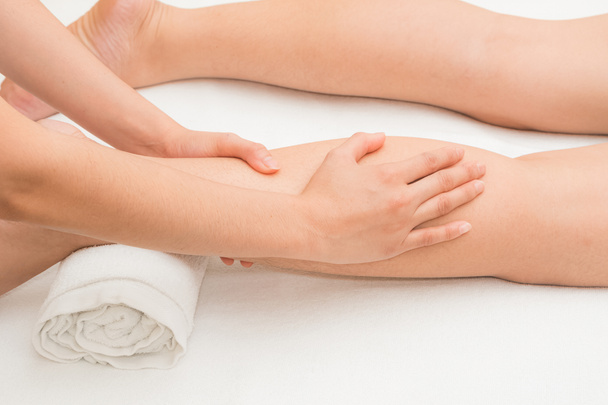 Thérapeute faire massage sur la jambe de la femme dans le spa de jour
 - Photo, image