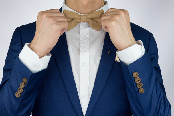man blue suit bowtie, brooch, pocket square - 写真・画像