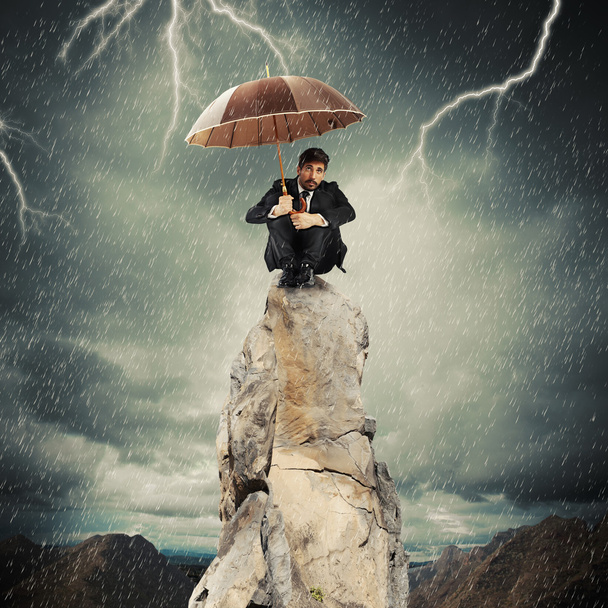 uomo d'affari con ombrello in cima alla roccia
 - Foto, immagini