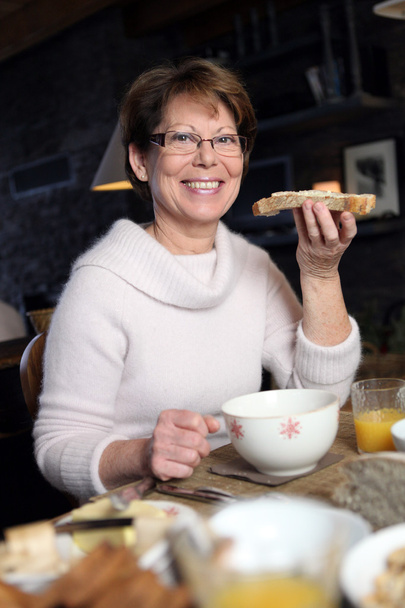 Woman eating a slice of bread - Фото, изображение