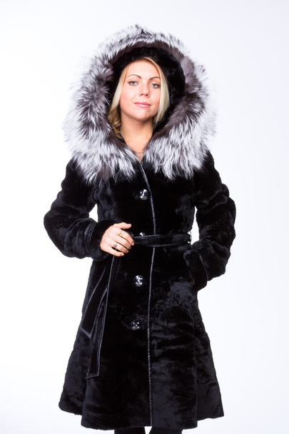 Young beautiful blonde girl in a black fur coat  with a belt - Fotoğraf, Görsel