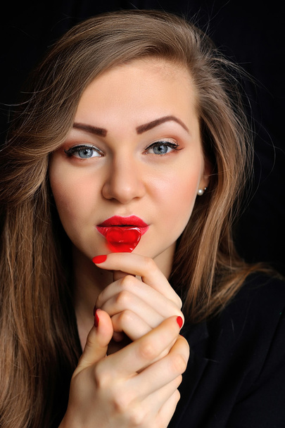 Gyönyörű lány piros cukorka szívvel ajkán - Fotó, kép