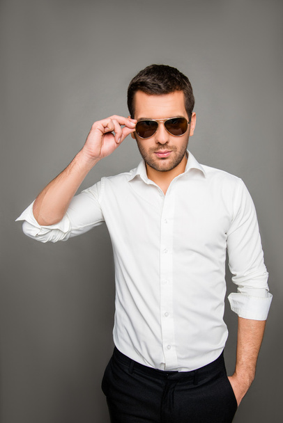 Photo of serious man in spectacles holding hand in pocket and to - Foto, immagini