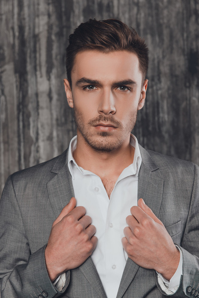 Attractive man in suit on the grey background - Photo, Image