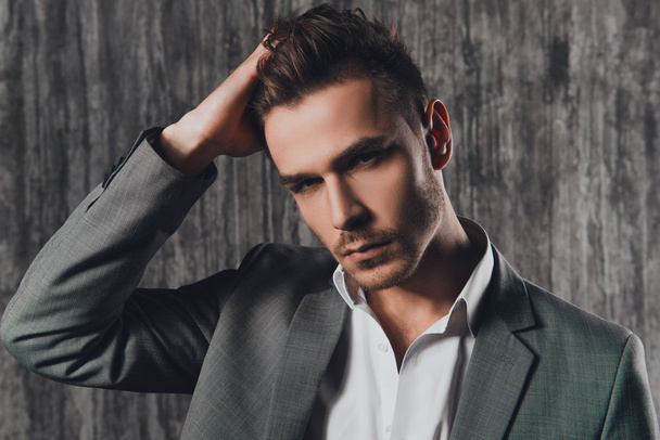 Attractive rigid man in business suit on the grey background - Fotografie, Obrázek