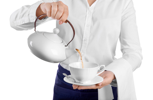 Waiter pouring tea into cup on white background - Photo, image