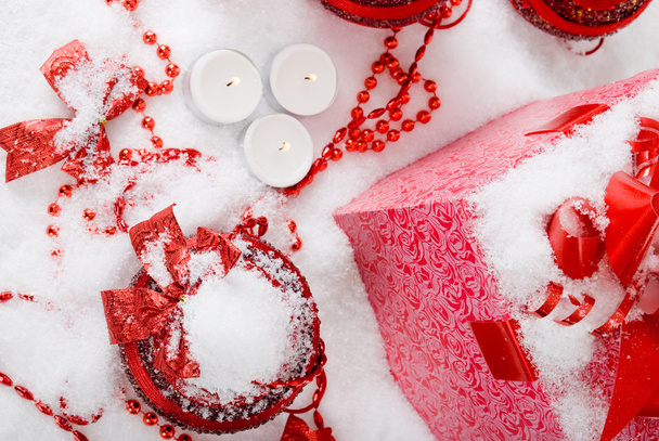 Christmas gift box in the snow with red balls and candles - Zdjęcie, obraz