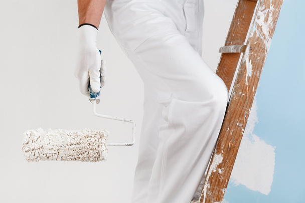 pintor con rodillo de pintura en escalera
 - Foto, imagen
