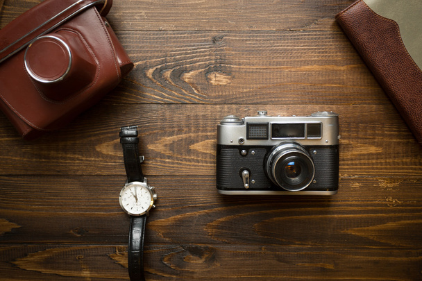 Вид сверху на винтажную камеру, ноутбук и часы на деревянном бэкграунде
 - Фото, изображение