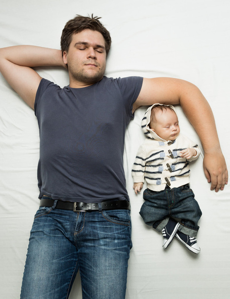 Top view portrait of  father and baby boy sleeping on bed  - Photo, Image