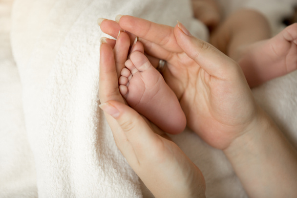 Toned tiro de recém-nascido pés de bebê em mãos mães
 - Foto, Imagem