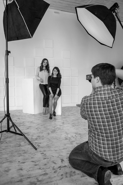 Black and white photo of photographer making shots of two girls - Foto, Bild