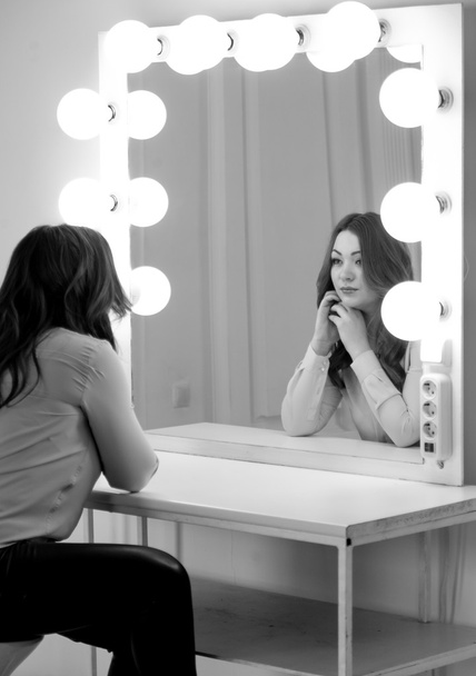 Monochrome portrait of brunette woman looking at reflection in m - Foto, Imagen