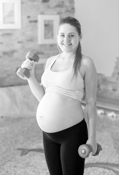 Ασπρόμαυρο πορτρέτο του χαμογελαστό έγκυος γυναίκα που ποζάρει με d - Φωτογραφία, εικόνα